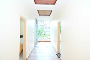 A bright hallway with a skylight and a view of greenery outside.