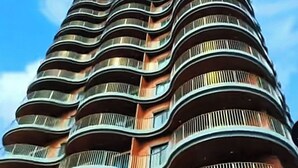 Un immeuble de grande hauteur doté de nombreux balcons et d’une enseigne bien visible sur laquelle on peut lire « MIRAGE ».