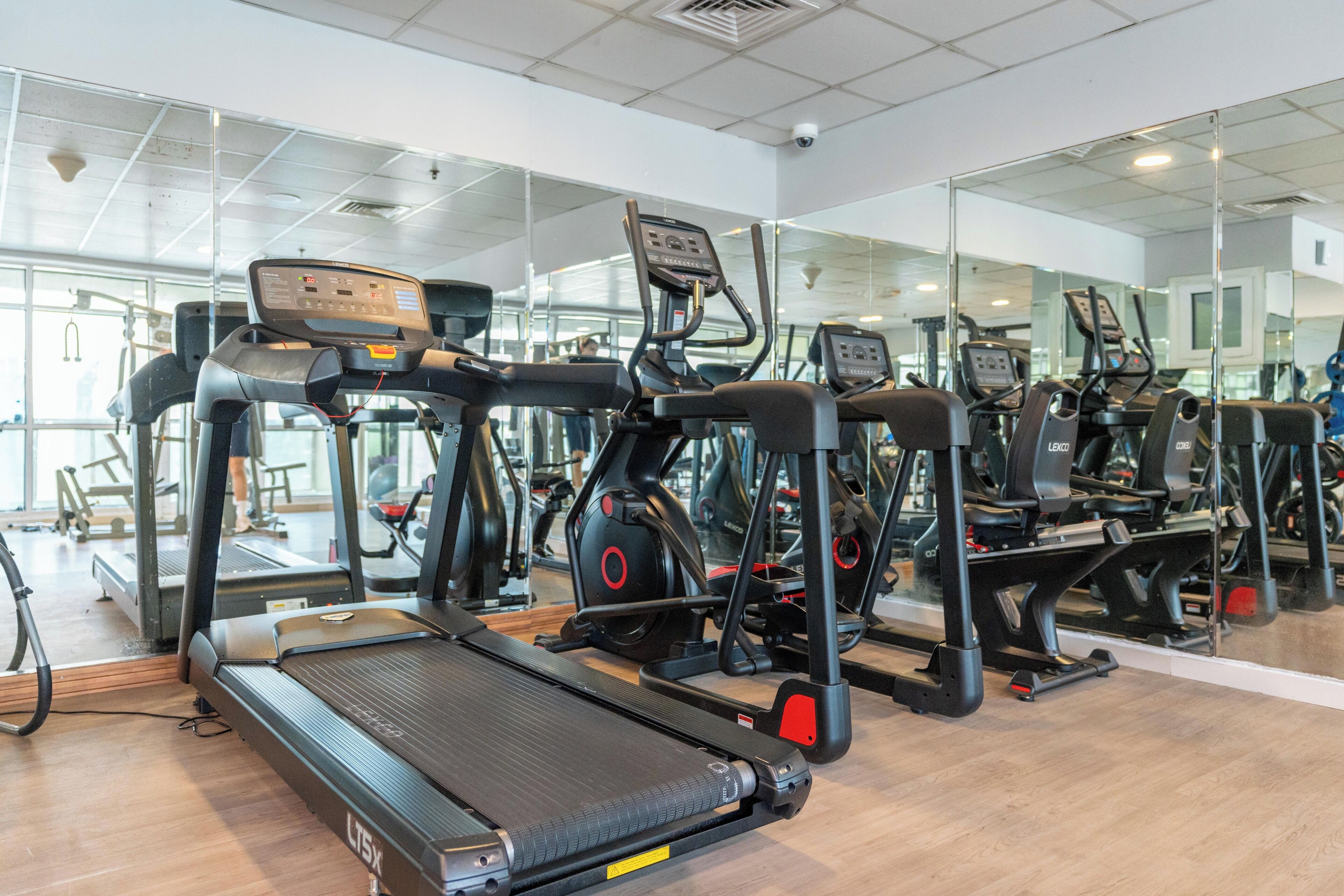 A gym with treadmills, elliptical machines, and weight equipment.