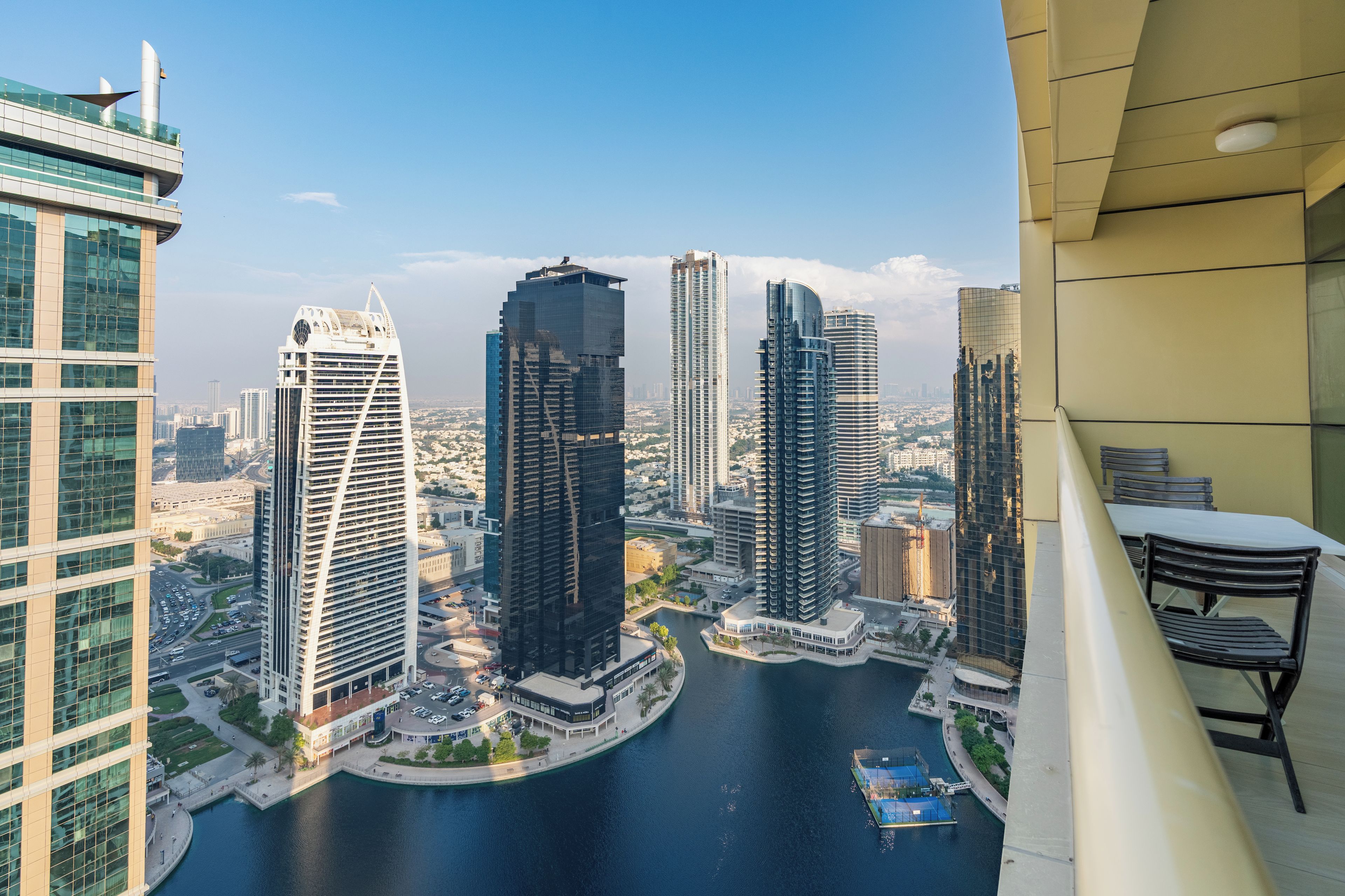 A high-rise building with a view of a river and other buildings.