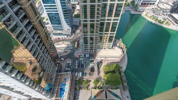 A high-rise building with a view of a marina and a road with vehicles.