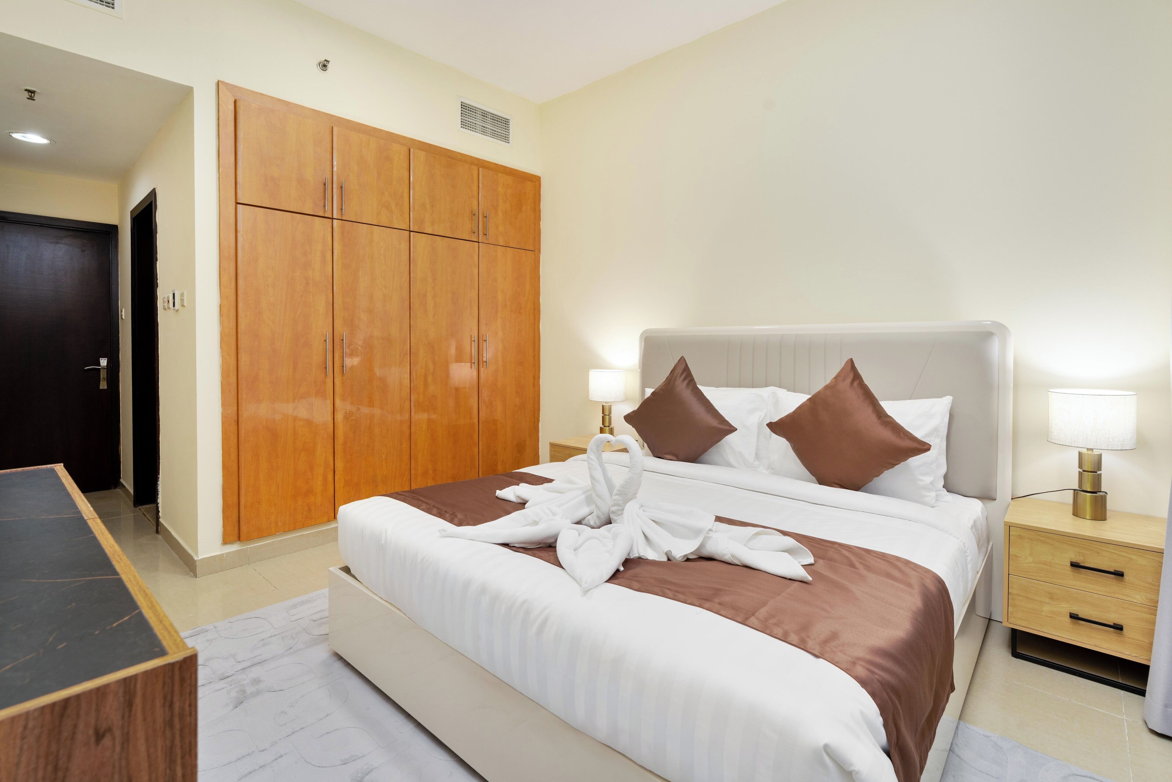 Une chambre d’hôtel comprenant un lit, des tables de chevet, une armoire et un bureau.
