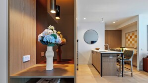 Une cuisine moderne avec un îlot central, un miroir rond au-dessus de l’évier et un plancher en bois.