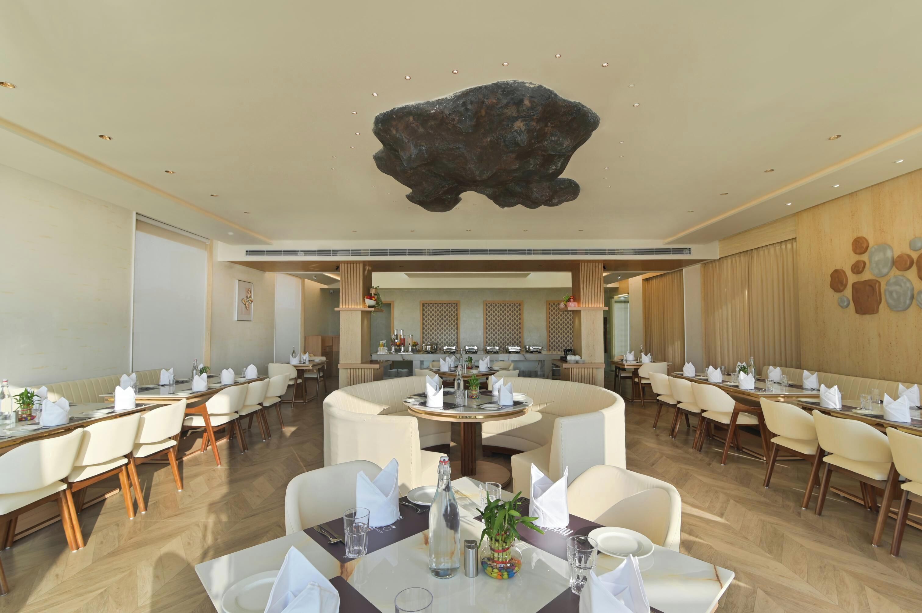 A restaurant with round tables, chairs, and a central bar area.