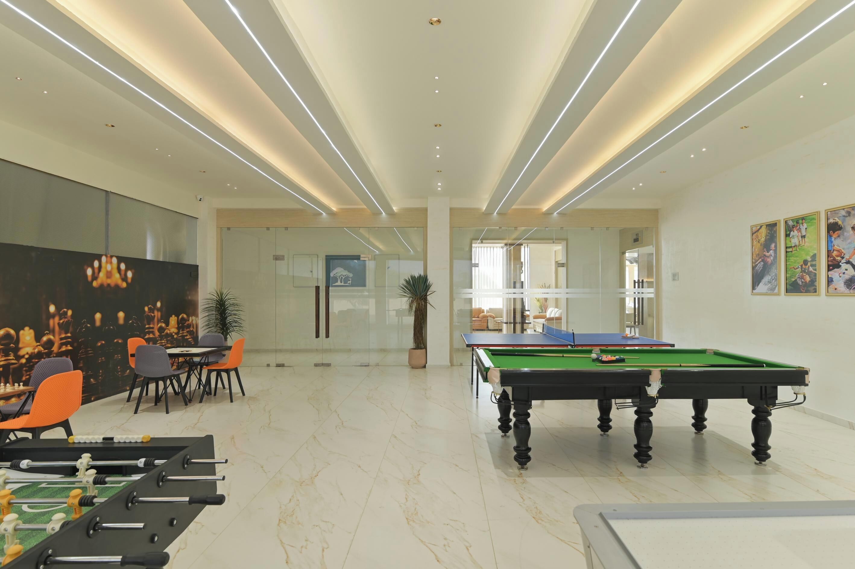A modern indoor recreational area with a pool table, foosball table, and seating area.