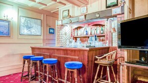 A bar area with wooden stools, a bar counter, and a television. - Standard Double Room (Gateshead)