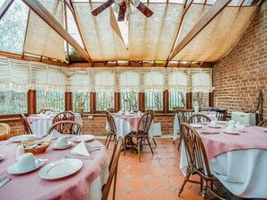 A restaurant with brick walls, large windows, and tables set with white tablecloths and pink table runners. - Standard Double Room (Gateshead)