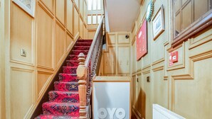 A staircase with patterned carpet, wooden walls, and a white radiator. - Standard Double Room (Gateshead)
