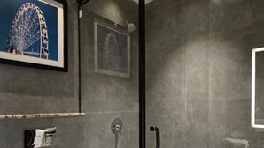 Un baño moderno con cabina de ducha de vidrio, inodoro y lavamanos.