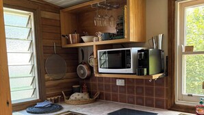 A compact kitchen with wooden cabinets, a microwave, a coffee maker, and a dishwasher. - "The Valley " Studio Kentucky. Set on a quiet country rd  with a divine outlook. (Kentucky)