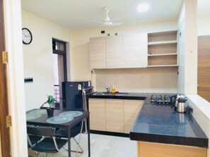 Frigorífic, placa de cuina i una taula de menjador 