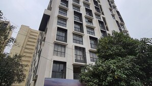 Un edificio alto y moderno con varios pisos, ventanas amplias y balcones.