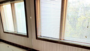 A bathroom with a large bathtub, a mirror, and two windows with blinds. - Delaware Water Gap River, Hiking, Jacuzzi Townhouse (East Stroudsburg)