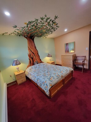 Une chambre à coucher avec un grand lit, une table de chevet, une commode, un bureau et un tableau accroché au mur.