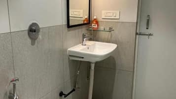 A modern bathroom with a white sink, a mirror, and a toilet.