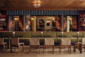 A restaurant with a green booth seating area, wooden tables, and chairs. - South Lamar Stay w/ Private Balcony | Pool, Terrace, On-Site Dining | The Code (Austin)