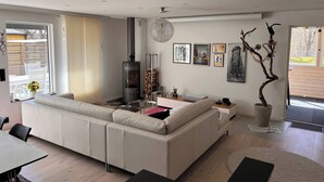 Uma sala de estar moderna com sofá, lareira e obras de arte na parede.