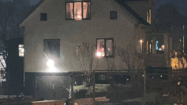Une maison à deux étages, dotée d’un toit en pente, de nombreuses fenêtres et d’une cheminée bien visible.