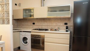 Una cucina compatta con lavatrice, forno e microonde integrati.