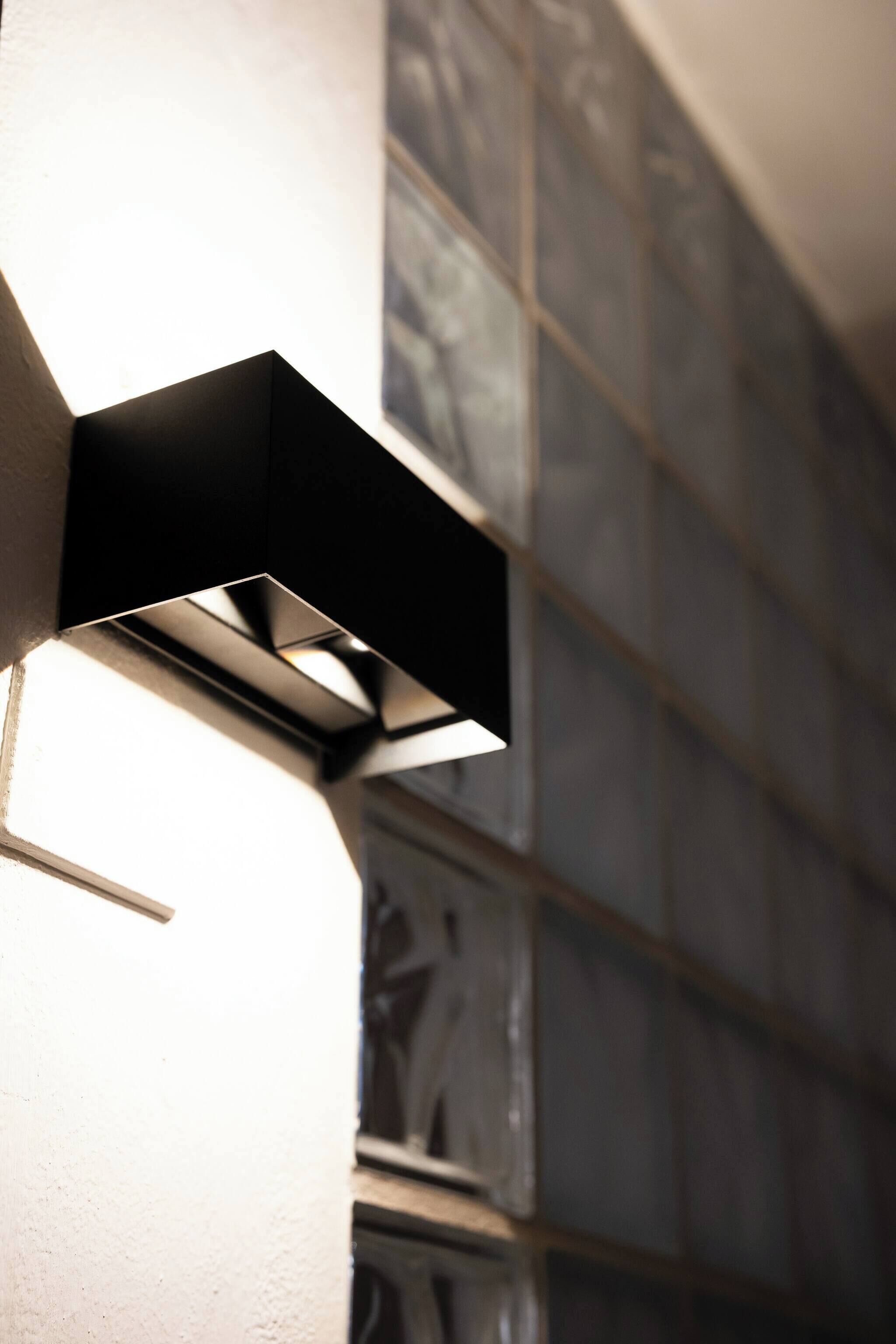 Een moderne buitenlamp bevestigd aan de gevel van een gebouw.