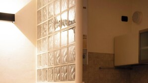 Una cucina funzionale con lavatrice, un tavolo da pranzo con sedie e un rivestimento a mosaico.