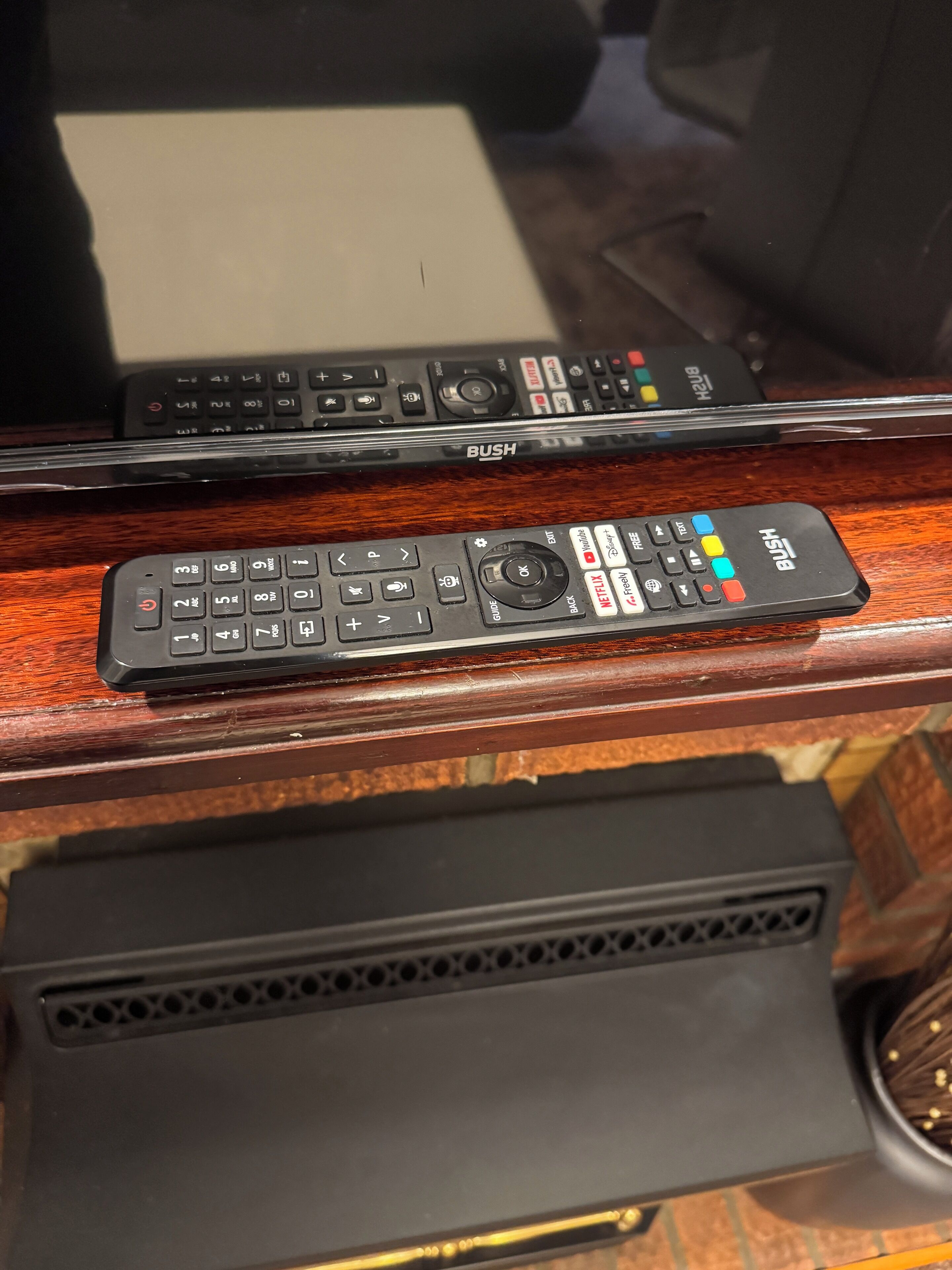 Dos controles remotos sobre una superficie de madera.