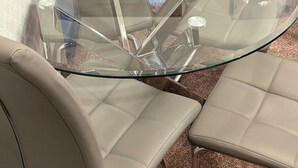 Un tavolo da conferenza con quattro sedie, un piano in vetro e una struttura in legno.