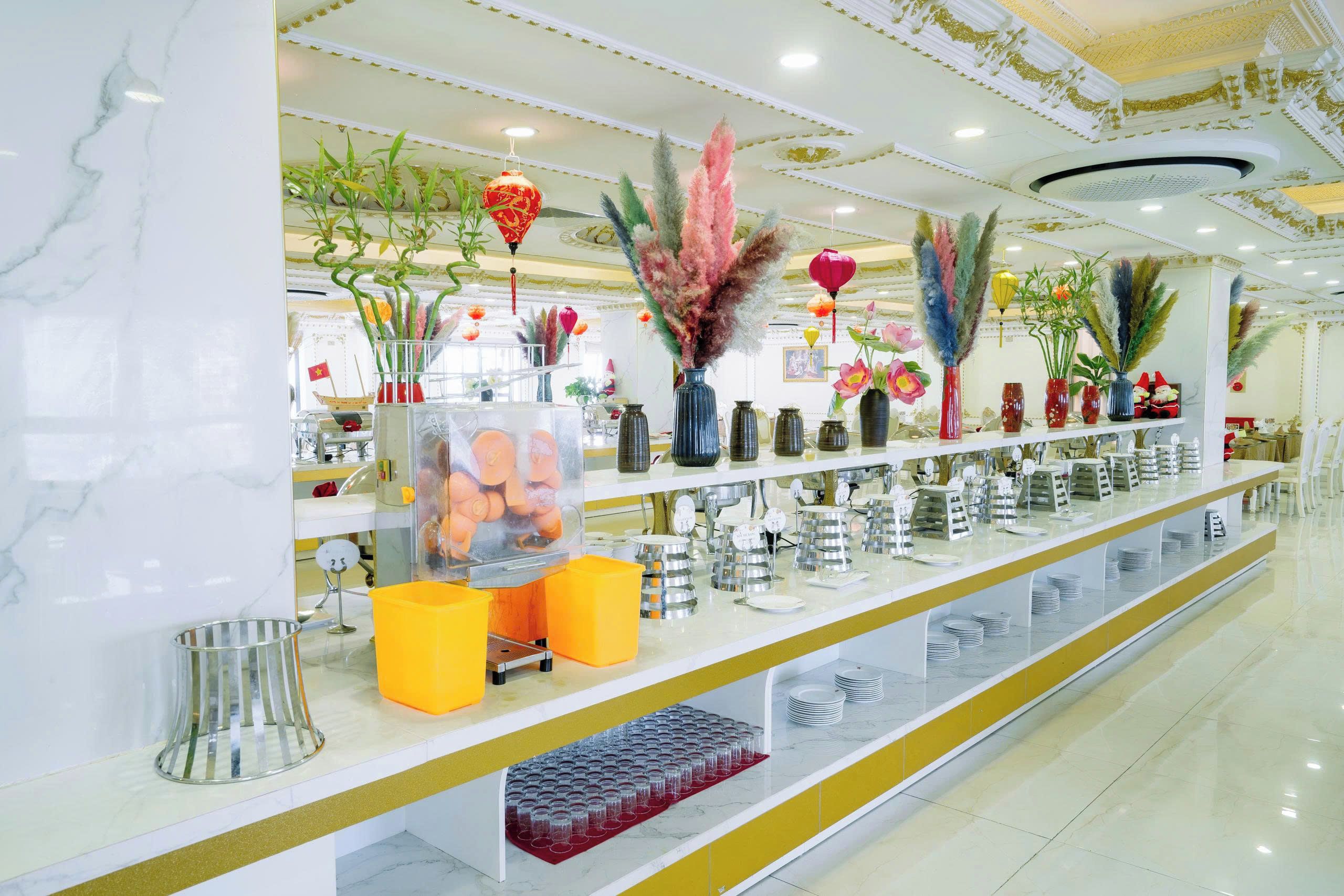 A well-lit, modern interior with a marble floor, a long counter with various items, and decorative plants.