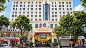 A multi-story hotel with a prominent entrance, a large sign reading 'Phoenix,' and several storefronts on the ground level.
