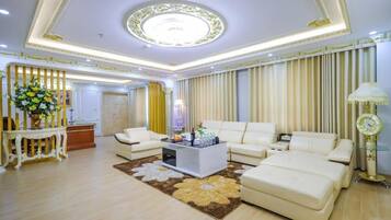 A spacious living room with a large sofa set, a coffee table, and a decorative rug.