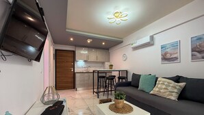 Ein modernes Wohnzimmer mit einem grauen Sofa, einem weißen Couchtisch und einem an der Wand befestigten Fernseher.
