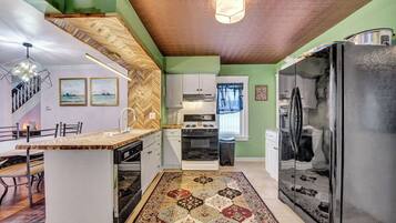 Een koelkast met diepvriezer, een microgolfoven, een oven, een kookplaat