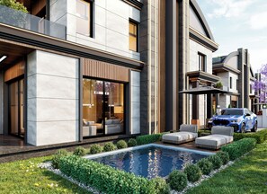 Een modern huis met een zwembad, buitenmeubilair en een geparkeerde auto.