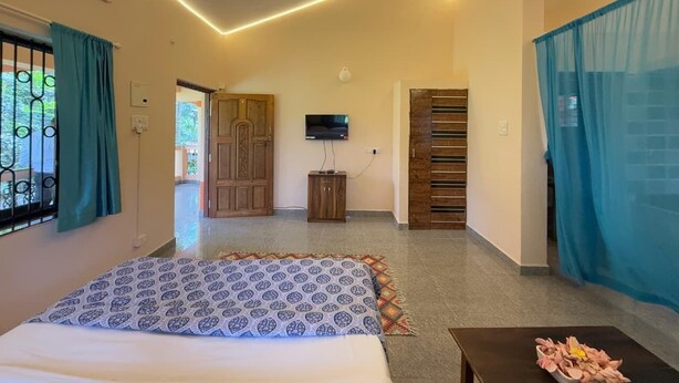 A bedroom with a bed, a ceiling fan, a television, and a small cabinet. - The Para Studio by Smith & Appy (Parra)