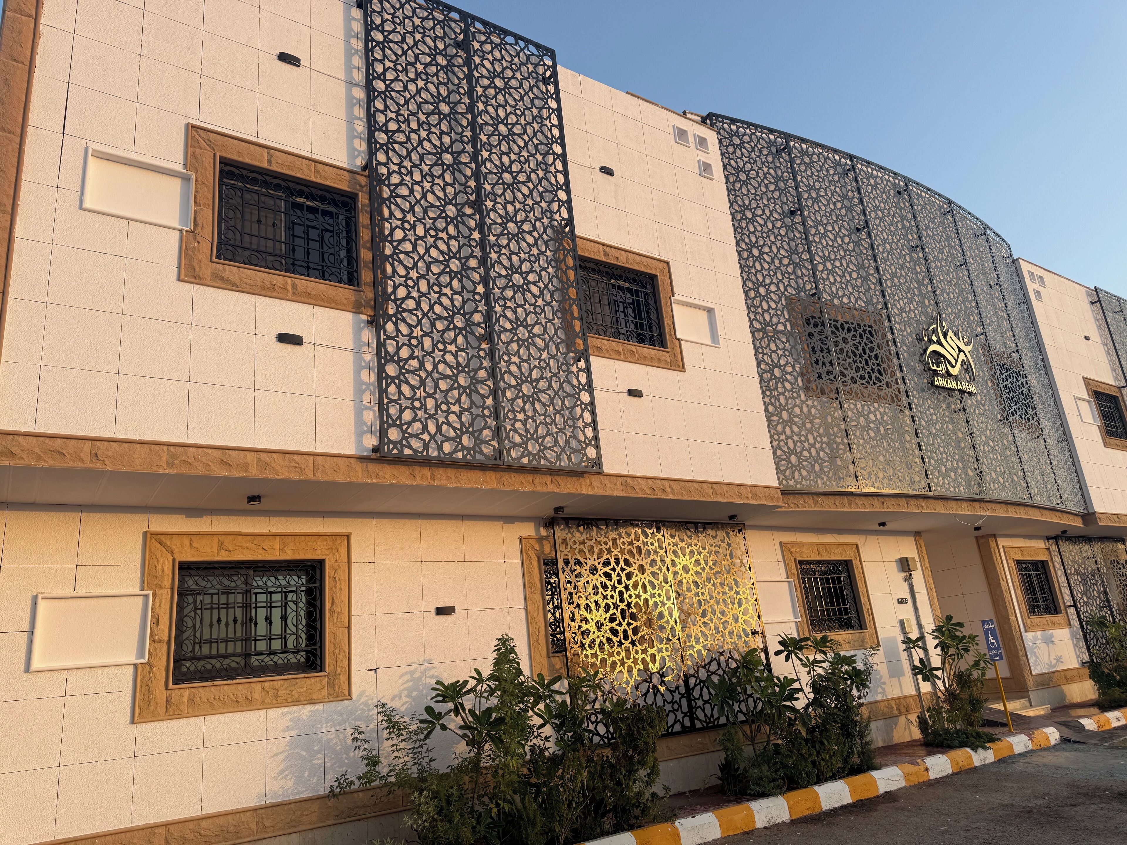 A building with a modern architectural design, featuring geometric patterns on the facade, multiple windows, and a prominent logo.