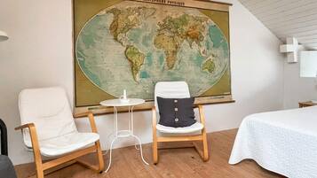 A room with two chairs, a small table, and a large world map on the wall.
