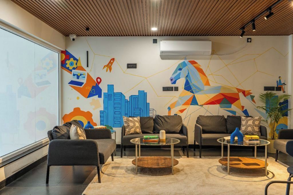 Un espace de détente moderne comprenant deux canapés, une table basse et une fresque murale décorative.
