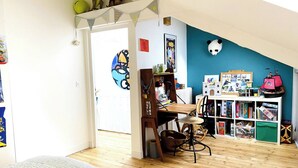 A room with a wooden floor, a desk with a chair, a bookshelf, and a panda head decoration on the wall. - House Nantes center in private cul-de-sac (Nantes)