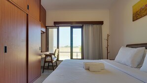 Et hotelværelse med en seng, et skrivebord og udsigt ud