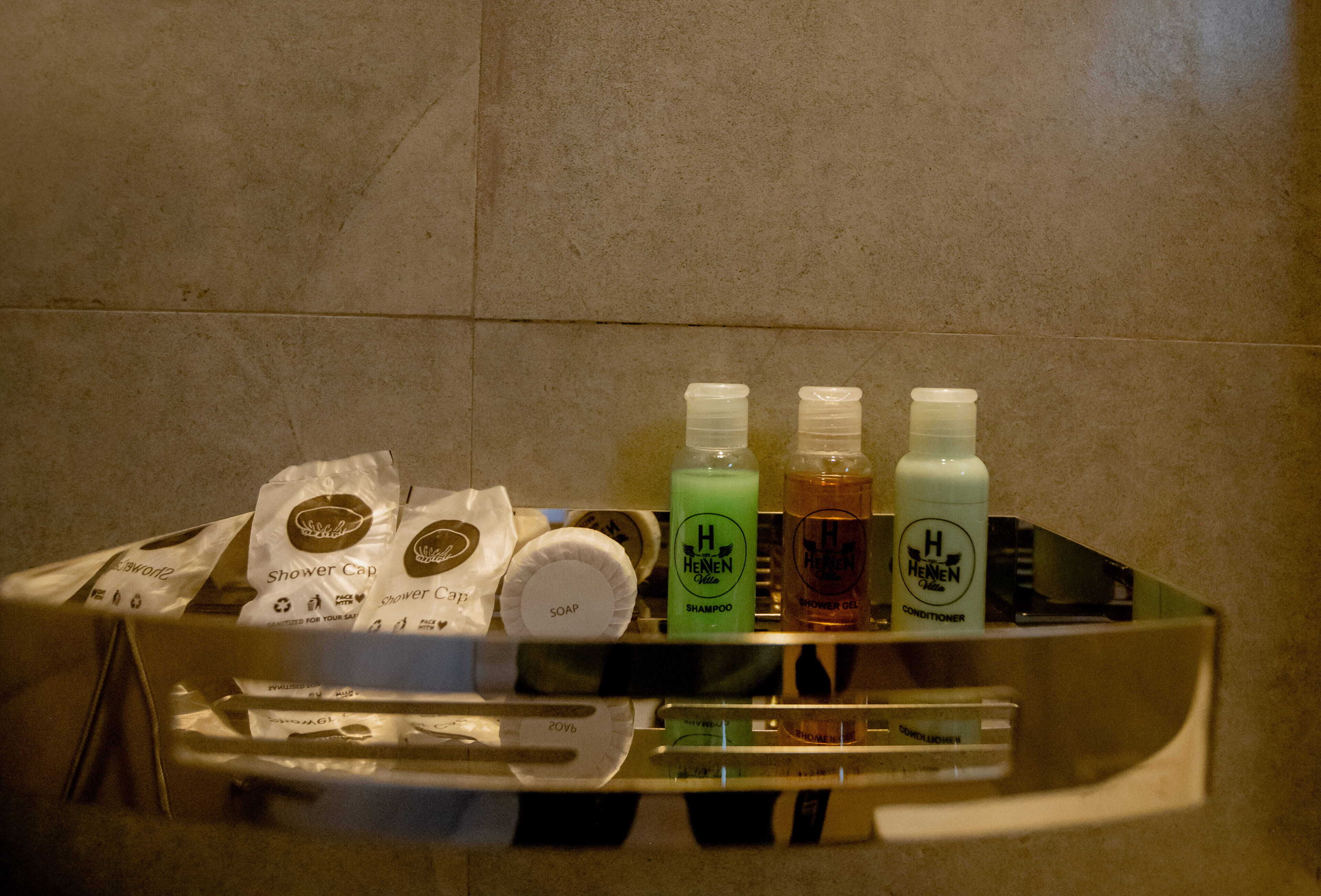 Ein Badezimmer mit Waschbecken, Spiegel und Pflegeprodukten, darunter Seife, Shampoo und Conditioner.