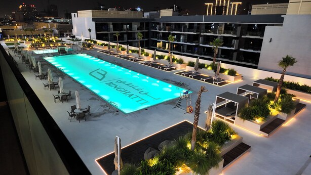 A rooftop pool area with a sign reading "BINGHATT".