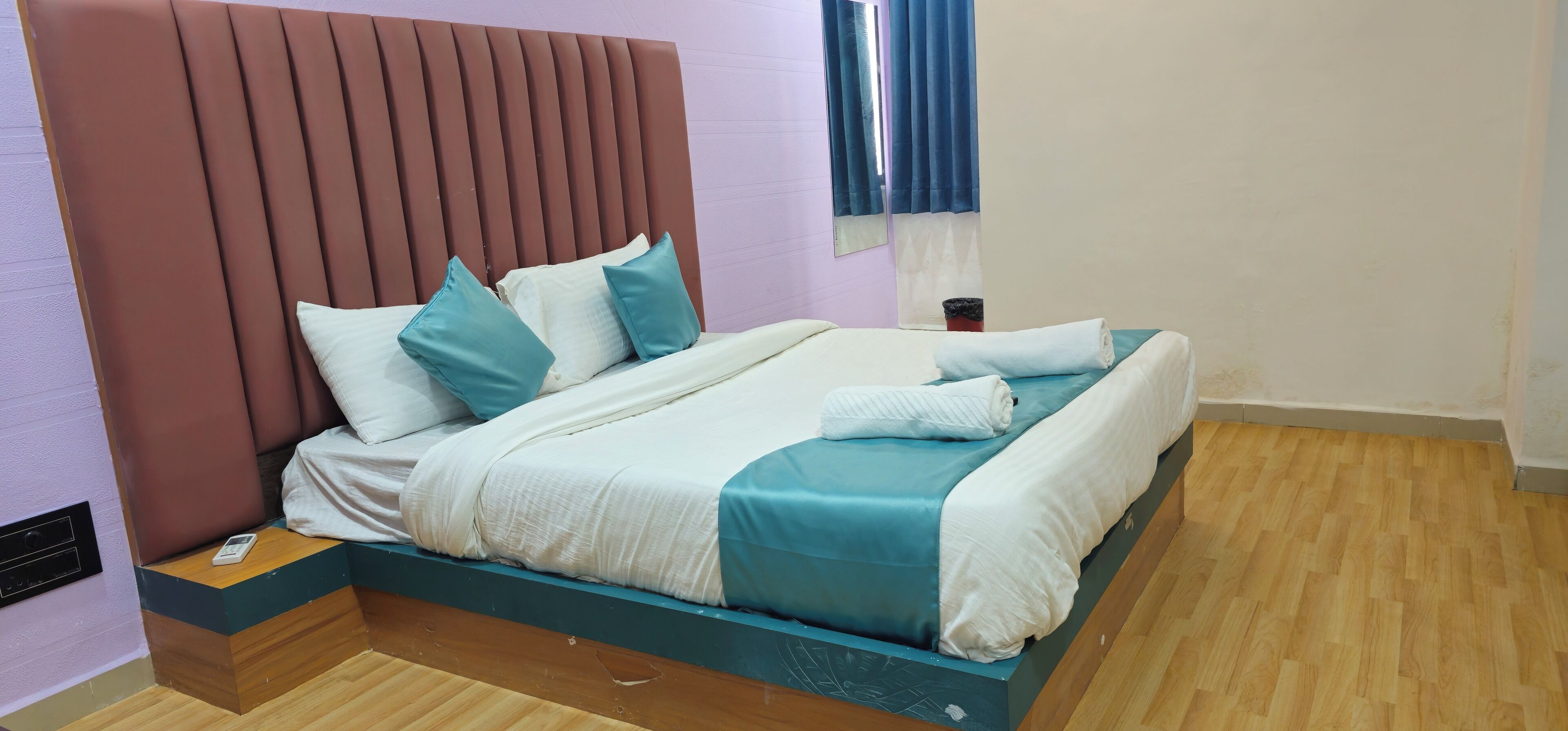 Una cama bien hecha con cabecera, almohadas y colcha.