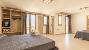 A spacious bedroom with a large bed, a wardrobe, and a small table. - Roomsalentopalace (Torre San Giovanni)