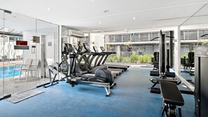 Un gimnasio moderno con cintas de correr, elípticas y bancos de pesas.