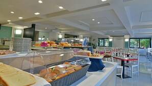 Ein Buffetbereich mit verschiedenen Speisen und eine Sitzgelegenheit mit Tischen und Stühlen.