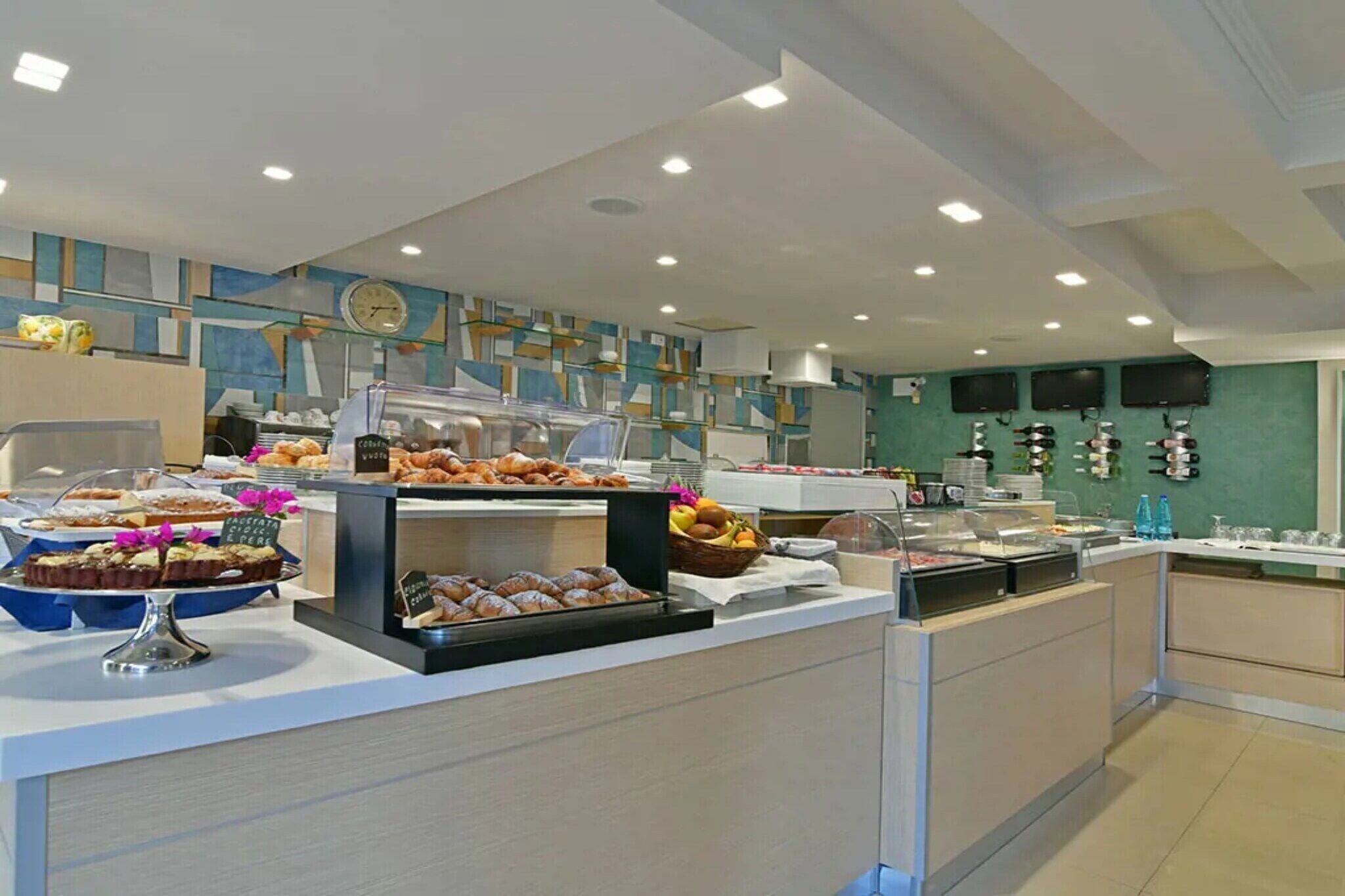 A buffet area with various food items and a clock on the wall.