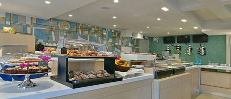 A buffet area with various food items and a clock on the wall.