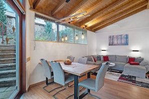 Un intérieur moderne comprenant un coin repas, un canapé et des œuvres d’art.