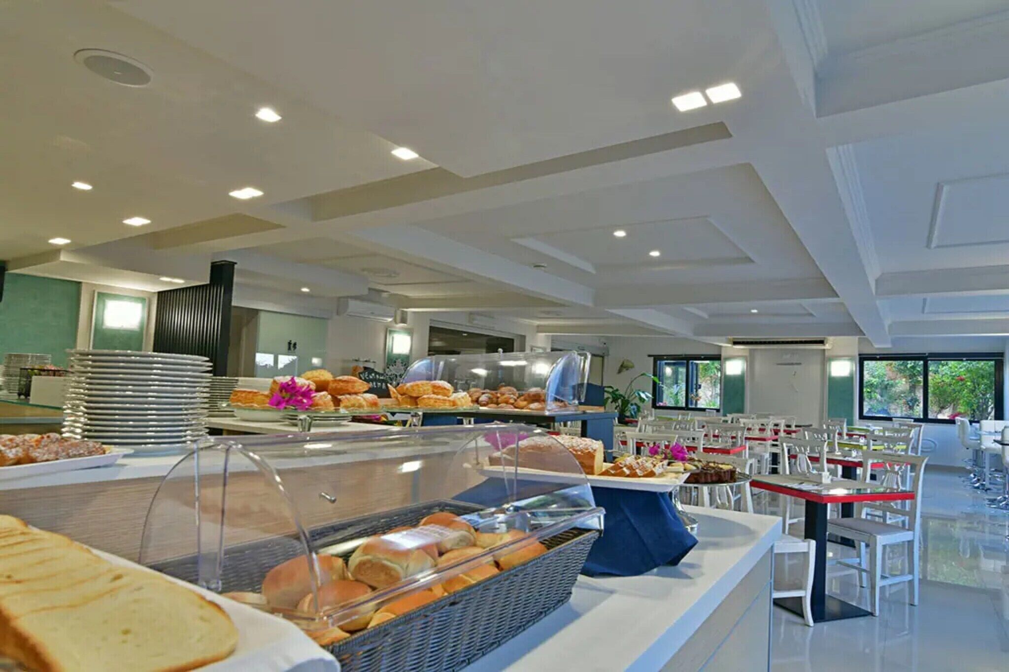 En buffet med forskellige spisemuligheder og et siddeområde med borde og stole.