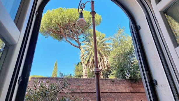 Blick durch ein Autofenster auf eine Straßenlaterne, eine Palme und eine Ziegelwand.